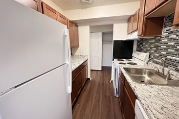 A kitchen with a white refrigerator and a white dishwasher.